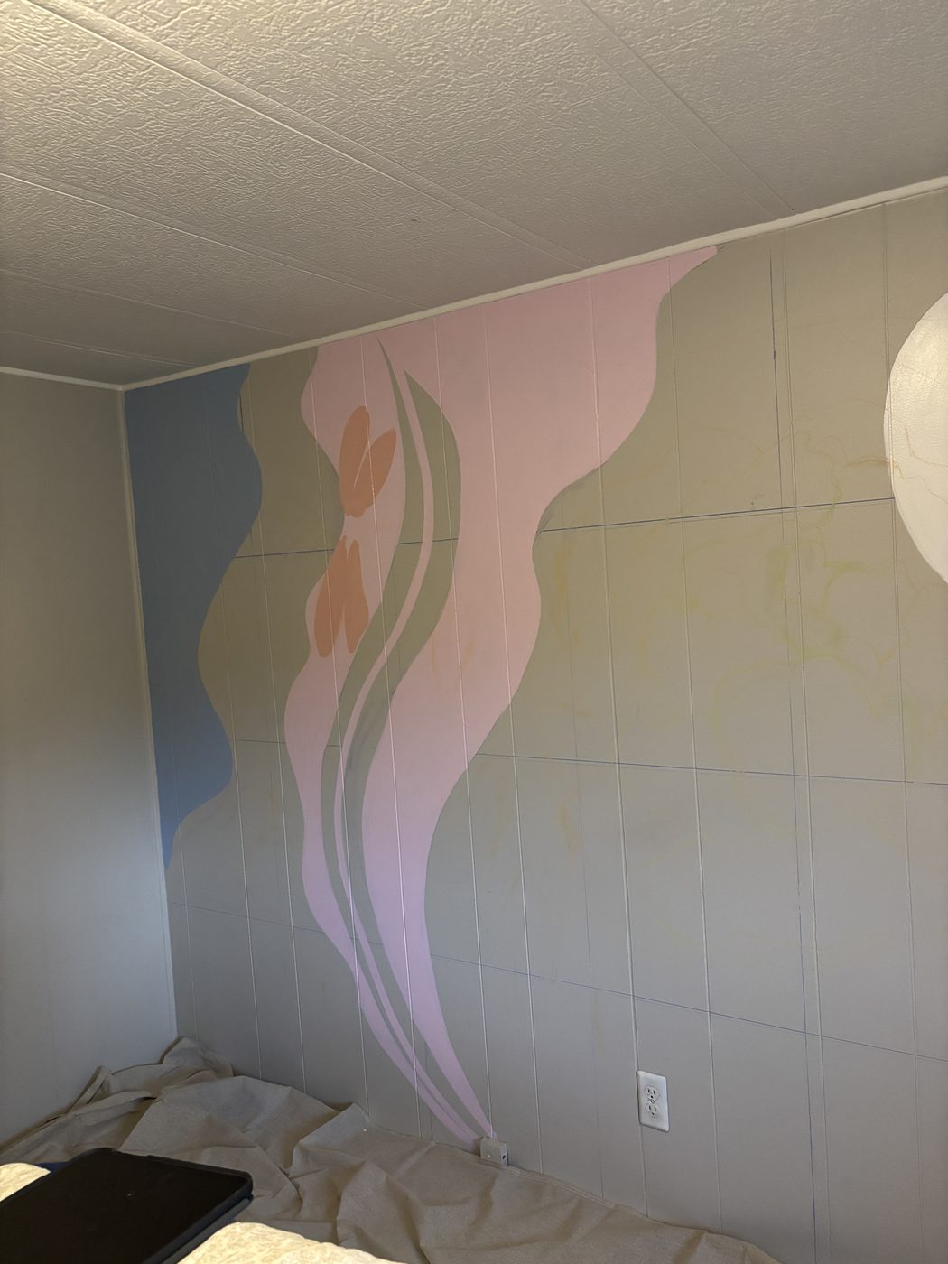 Bedroom wall painted with flowing pastel waves in lavender, sage, pink and blue with a cream moon